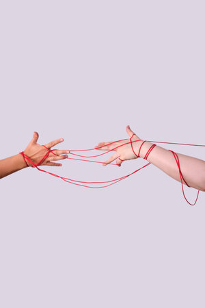 Hands connected by red string of fateの写真素材