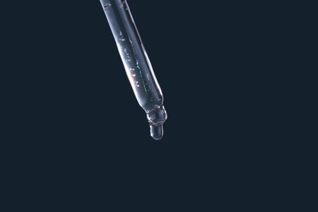 Dropper tip dispensing liquid forming a drop