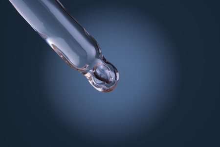 Dropper tip holding clear liquid drop, science conceptの写真素材