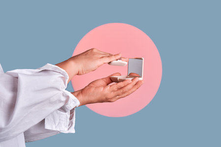 Hands holding compact powder and mirrorの写真素材
