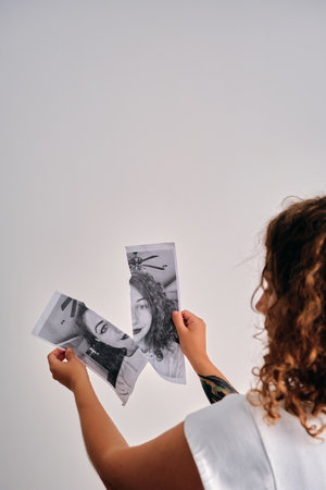 Woman holding pieces of a torn black and white portraitの写真素材