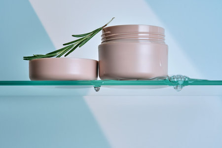 A jar of rosemary cream on the glass shelf of the bathroom.の写真素材