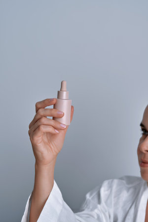 Woman holding skincare serum dropper bottleの写真素材