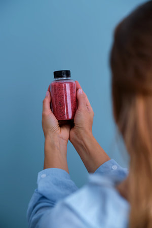 Woman holding bottle with granular supplementの写真素材