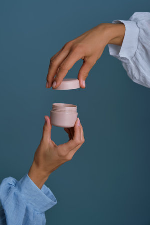 Hands opening cream jar for beauty skincare routineの写真素材