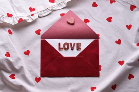 Love letter in red envelope on heart pattern