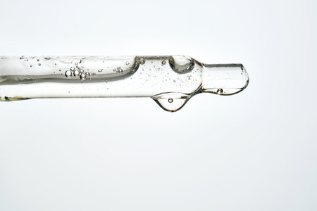 Cosmetic pipette dispensing serum with many bubblesの写真素材