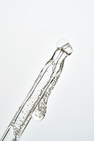 Cosmetic pipette dropping liquid serum with bubbles
