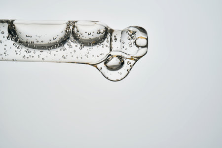 Cosmetic pipette dropping serum or oil with bubblesの写真素材