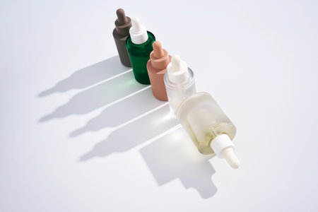 Skincare serum bottles with droppers creating shadow line