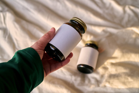 Hand holding supplement bottle with blank label