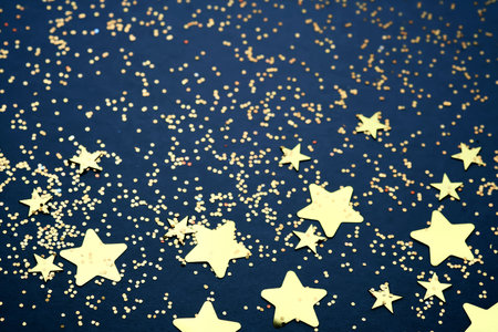 Abstract festive blue background with golden stars.