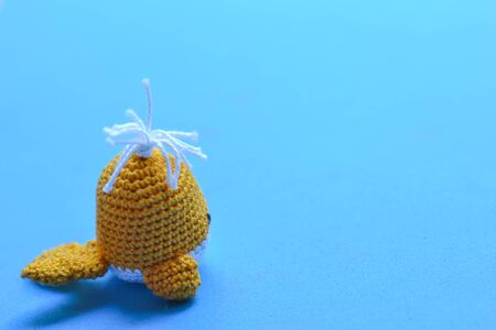 Crochet whale swimming on a blue backgroundの写真素材