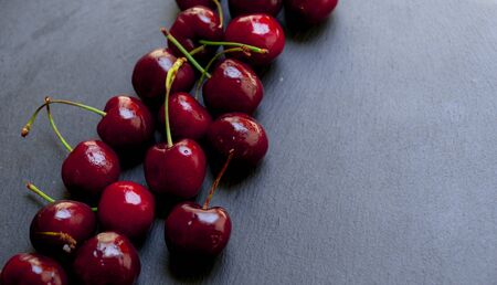 Various cherries on black chalkboard backgroundの写真素材