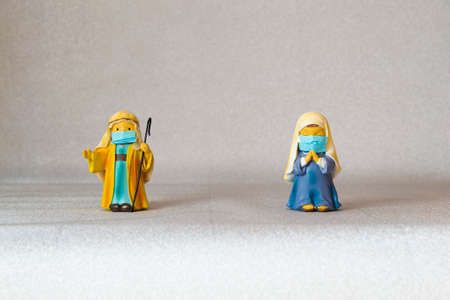 Figures of Saint Joseph and the Virgin Mary with hygienic masks and with a safety distance. Christmas with the Covid-19 pandemicの写真素材
