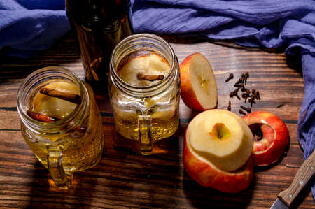 A wooden table with apples and a delicious cider. Typical autumn drinkの写真素材