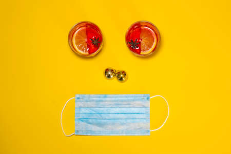 Overhead shot of a one-sided composition with glasses of mulled wine, Christmas balls, and a surgical mask. Concept of celebrating Christmas during the Covid-19 pandemic. Copy spaceの写真素材