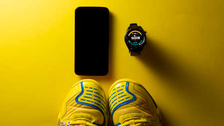 Close up of a black smartwatch on an orange background, similar to a watch face. Technology and...