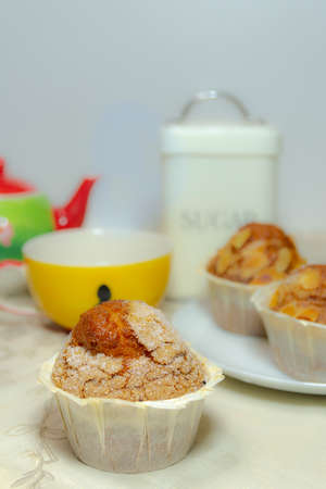 Close-up of a breakfast: three muffins, a cup, a teapot and a jar with sugar. Horizontal photography and copy spaceの写真素材