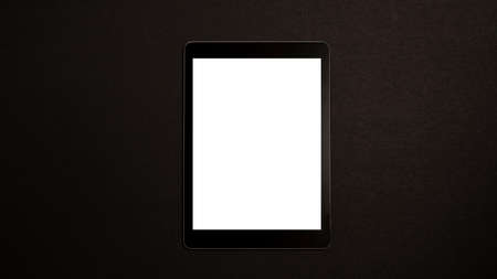 Mockup of a tablet on a black background. Wireless technology and tablet usage concept. Horizontal photography.の写真素材
