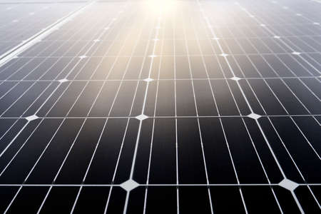 Close-up of solar panels under the blue sky illuminated directly by the sun. Solar energy and sustainable energy conceptの写真素材