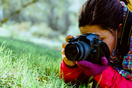 Close-up of a photographer on the ground taking nature photos. Unrecognizable person and copy space.の写真素材