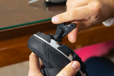 Close-up of a man's hands assembling his cycling carbon road shoes and attaching cleats for pedals....