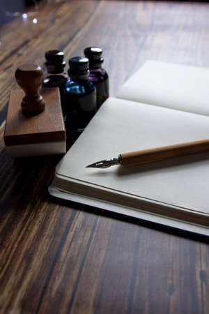 Close-up of a fountain pen on a notebook and several inkwells.の写真素材