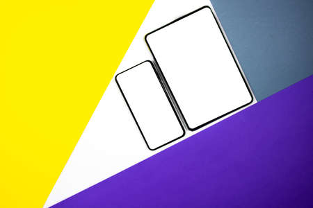 Mock up of a smartphone and a tablet on different colored backgrounds.