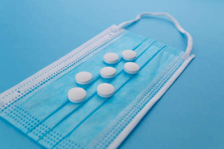 Aerial view of several pills on a surgical mask. Concept of drugs for the treatment of diseases, especiallyの写真素材