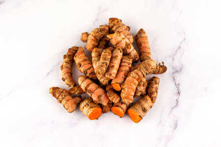 Set of various turmeric roots on a marble table. Concept of natural medicine and homeopathyの写真素材