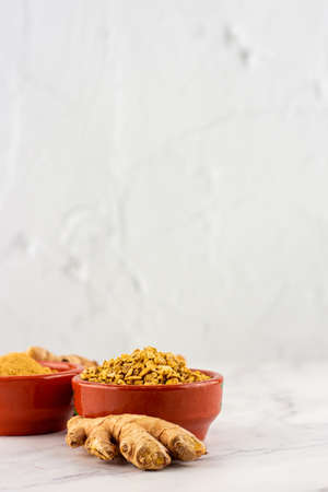 Background with several clay bowls with powder and ginger root on a marble table. Concept of natural medicine and homeopathyの写真素材