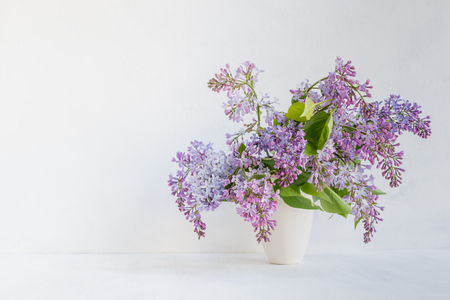 Bouquet of lilac in a vase on a light background. Interior decor.の写真素材