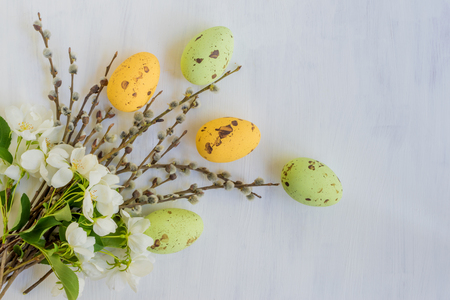 Easter eggs willow branches and white spring flowers on a light backgroundの写真素材