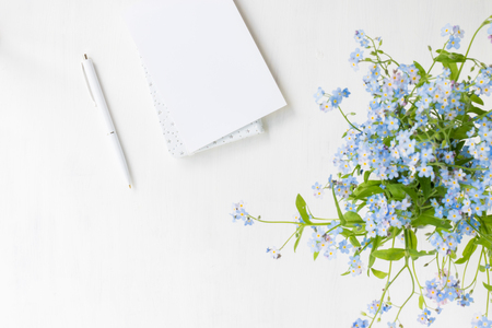 Flat lay desk with with blue flowers on light backgroundの写真素材