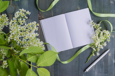 Mockup notebook with white spring flowers and rustic wooden background empty space for your text, top viewの写真素材