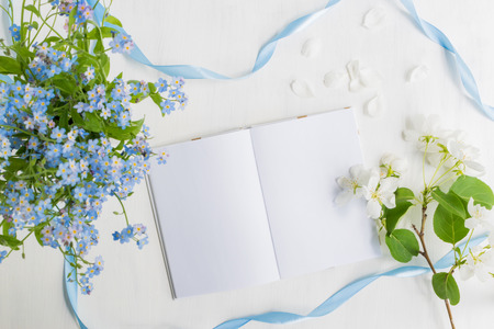 Mockup notebook with blue and white flowers and light backgroundの写真素材