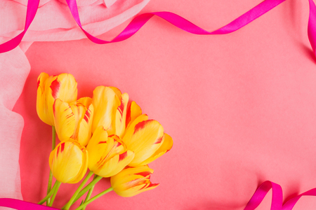 Yellow tulips flowers on a pink background empty space for your text, top viewの写真素材