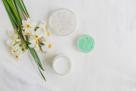 Body cream and bath salt with white narcissus on a light backgroundの写真素材