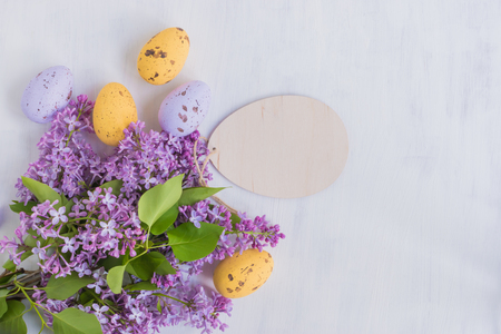 Easter eggs and lilac branches on a light backgroundの写真素材