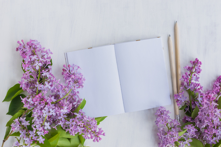 Mockup notebook with lilac branches and light background empty space for your text, top viewの写真素材