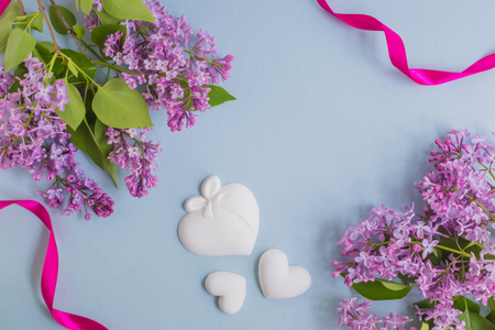 Lilac branches and pink ribbon on a light blue background empty space for your text, top viewの写真素材