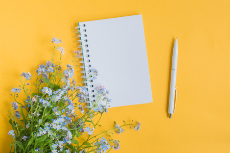 Mockup notebook with blue flowers and yellow backgroundの写真素材