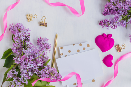 Flat lay desk with lilac branches and notebook on light backgroundの写真素材