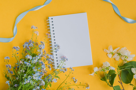 Mockup notebook with blue and white flowers and yellow backgroundの写真素材