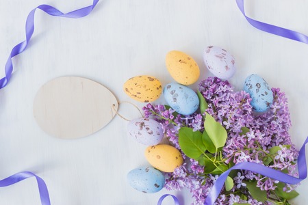 Easter eggs and lilac branches on a light backgroundの写真素材