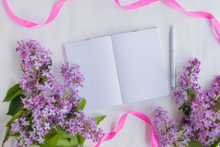 Mockup notebook with lilac branches and light background empty space for your text, top viewの写真素材