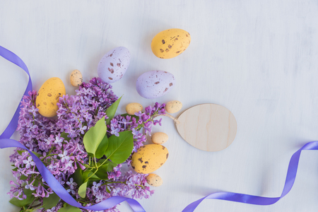 Easter eggs and lilac branches on a light backgroundの写真素材