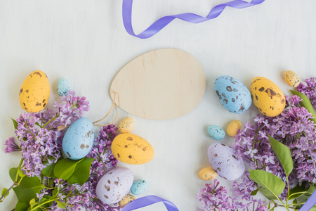 Easter eggs and lilac branches on a light backgroundの写真素材