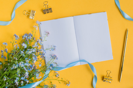Mockup notebook with blue flowers and yellow backgroundの写真素材